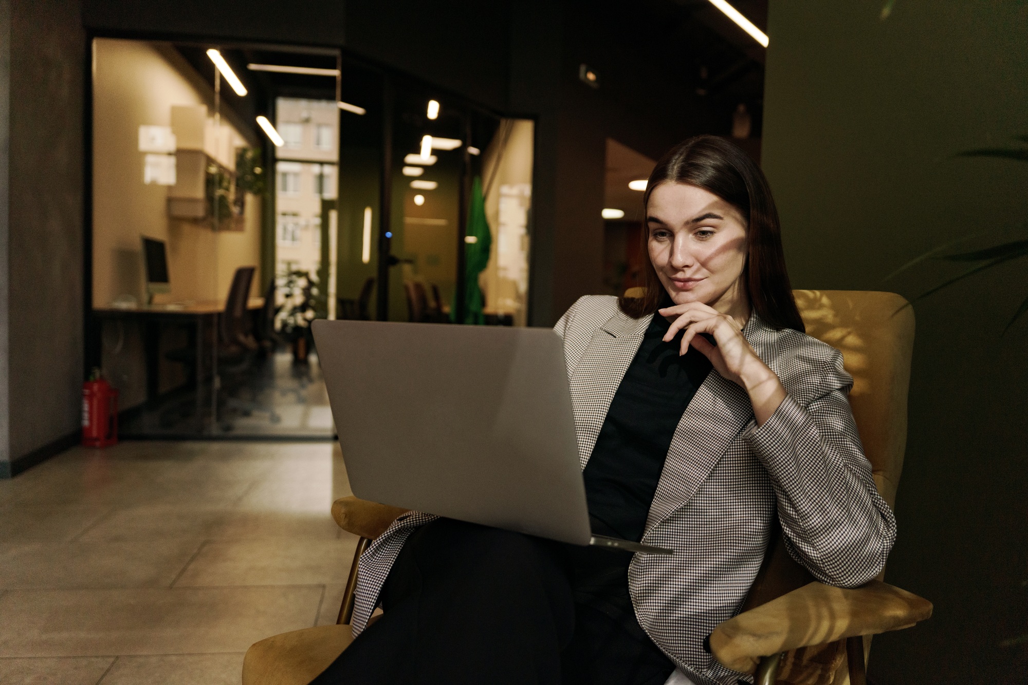 A young woman smiling emotion marketing specialist uses a new laptop and an AI chatbot for a project